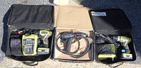 Two Ryobi cordless drills in cases along with portable chargers.