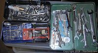 Overhead view of two metal cases containing a large collection of wrenches, socket attachments, ratchets, and hex key sets.