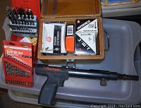 Full lot contents with the Ramset tool, drill bit sets, and fastener boxes in a plastic container.