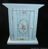 Front view of painted wooden cabinet with floral decoration