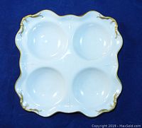 Top view of the 4-bowl white porcelain serving dish with gold trim, showing four rounded bowls and scalloped edges.