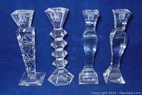 Four Towle crystal candlestick holders arranged side-by-side on blue background, showing two pairs of different matching designs.