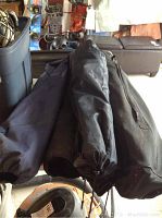 Five folding chairs in black carry bags, laid out horizontally showing the drawstring ends of the bags.