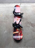Top view of Lamar Ultra 154 snowboard with black bindings attached, showing full length and design.