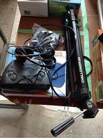 Photo showing the tripod base, wired headphones, GE clock radio, and Dexxa graphic tablet with cables visible