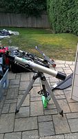 Swift telescope mounted on tripod outside on stone patio, showing overall item setup and orientation.