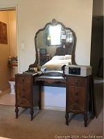 Full view of rosewood vanity table with attached mirror, showing drawers and turned legs