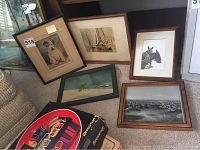 Five framed prints leaning on a couch and floor, showing various animal and outdoor themed art.