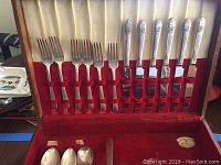Open red velvet lined wooden box showing 6 forks and 6 knives with Orleans pattern handles