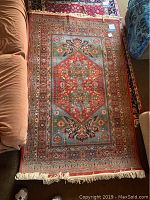 Full view of the rectangular area rug displaying the intricate colored pattern and fringe.