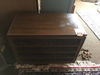 Wooden midcentury high fidelity console cabinet closed showing front speaker grilles and wood finish.