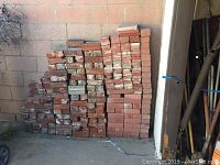 Bricks stacked against a wall showing the different stacks and view of the lot size.