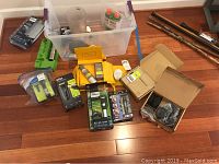 Overview of assorted men's shaving and haircut items including branded packaging and accessories on wooden floor.