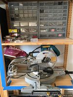 Top shelf with two plastic parts organizers and assorted hardware on shelf