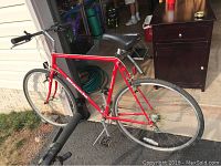 Side view of red Bianchi Advantage bike showing frame, tires, pedals and handlebars.
