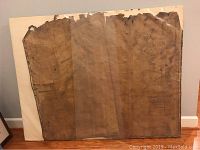 Full view of antique map still wrapped in protective plastic, mounted on foam board showing wear and fragility.