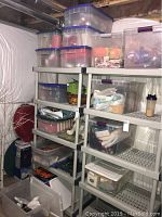 Photo showing multiple plastic storage bins holding crafting materials and holiday decorations on metal shelving in basement.
