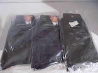 12-pack of men's dress socks individually wrapped in plastic packaging, predominantly black with subtle swirl patterns.