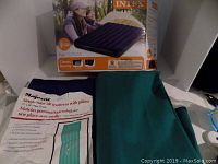 Photo shows one boxed Intex Classic Downey full size air mattress and two unboxed Majestic single tube air mattresses (green and purple) with their packaging visible.