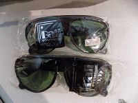 Two pairs of new Bali Eyewear Proball sunglasses in original plastic packaging showing branding and UV protection labels on lenses.