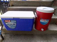 Blue and white Coleman 48QT cooler and red 5 gallon beverage cooler placed on steps side by side