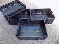 Four black collapsible plastic crates, three large and one smaller, shown assembled and standing open to display size and design.