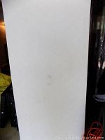 Top side of white folding table showing some wear and marks on the surface.