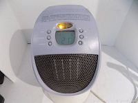 Front view of the Honeywell heater showing the digital screen lit with temperature and control buttons, and the protective grille over the heating element.