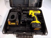 Dewalt drill/driver with charger and battery in black plastic case.