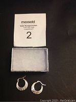 Pair of .925 silver hoop earrings next to a small presentation box and a MaxSold lot number card.