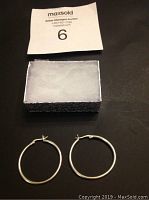 Pair of polished, circular .925 sterling silver hoop earrings shown with closed box and auction number card.