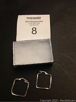 Pair of square-shaped .925 silver hoop earrings on a black surface with auction number 8 card.