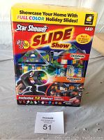 Front side of the product box showing 'Star Shower Slide Show' LED projector with 12 slides for full color holiday projection including Christmas and Halloween.