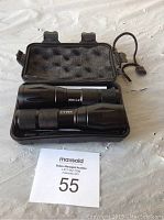 Two black expandable flashlights placed inside black carrying case with foam interior, showing front view of flashlights and case.