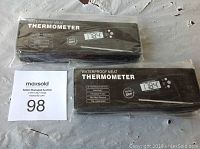Two unopened waterproof digital meat thermometers in black packaging, showing brand unknown, features including auto off, backlight, foldable probe, and 3-4 second response time.