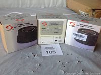 Photo showing two boxed Triplepower LED Camping Lanterns and one unboxed unit with LCD display and battery indicator.