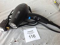 Black Infiniti PRO by CONAIR mini hair dryer with power cord and control switches visible.