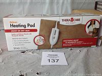 Box of Thera Care Deluxe Heating Pad featuring moist or dry heat options and product features.