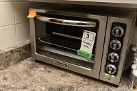 KitchenAid stainless steel countertop toaster oven with four control knobs and visible KitchenAid logo.