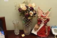 Photo showing the 16-inch tall angel figurine holding a stringed musical instrument dressed in red and gold fabric, next to a glass vase and dried flowers.
