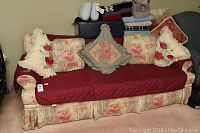 Full view of floral couch with cushions and quilted red cover