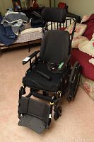 Front view of wheelchair showing seat cushion, armrests, footplate folded down