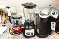 Oster blender, Kitchen Aid mixer, and Keurig coffee maker shown on counter with cords coiled.