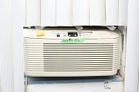 Front view of Plasmaire window air conditioner installed in window with measurement label