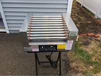 Overall view of stainless steel rotisserie unit on stand with ten rollers