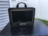 Front view of Axion 10 inch LCD TV monitor in black carrying pouch showing screen, speakers and control buttons