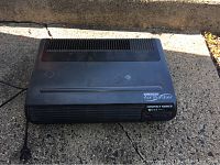 Full view of the Oreck air purifier showing its rectangular shape and vented top and front surfaces, power cord visible.