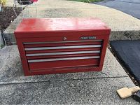 Front view of red Craftsman 4 drawer metal tool box showing logo and drawer handles