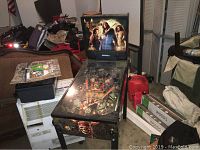 Full view of the Pirates of the Caribbean pinball machine showing overall size, surface artwork, and backglass featuring movie characters.