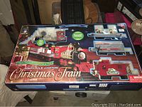 Front view of boxed North Pole Junction Christmas Train set showing overall packaging and train cars.